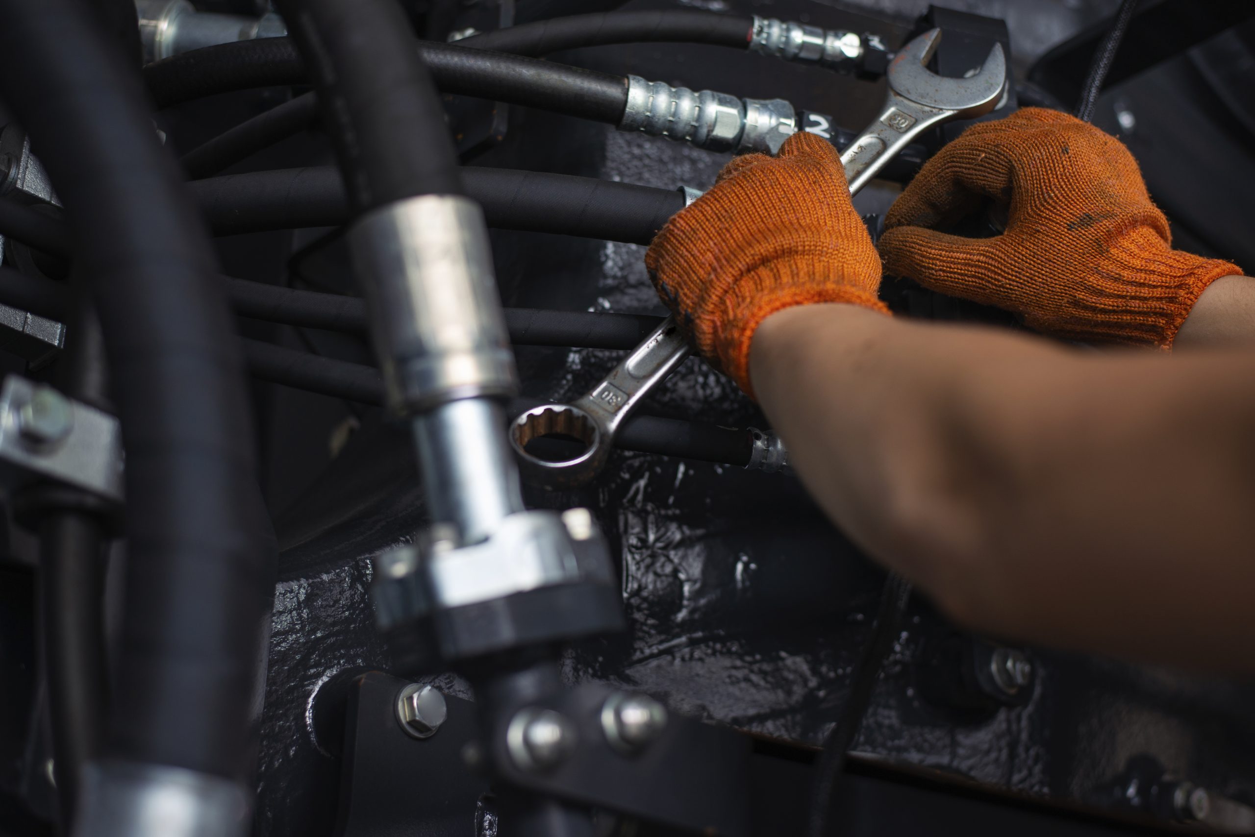 Close up view of hydraulic pipes of heavy industry machine. Low key. Hydraulic maintenance concept.